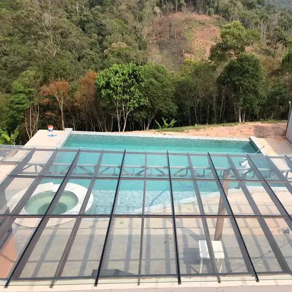 Cobertura de vidro sobre piscina com a serra ao fundo, obra da PS do Vidro